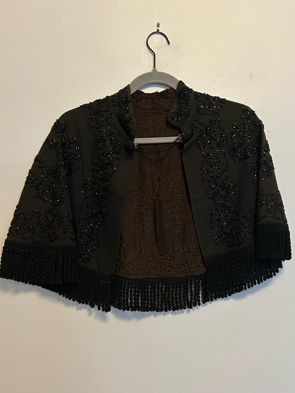 Black beaded fringe capelet jacket with floral embroidery and fringe trim